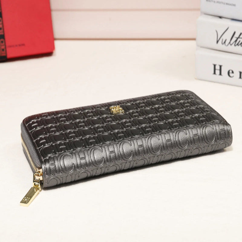Black embossed wallet with gold zipper on a light background