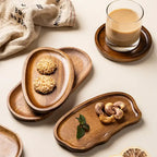 Wooden trays with cookies and a glass of tea on a light surface
