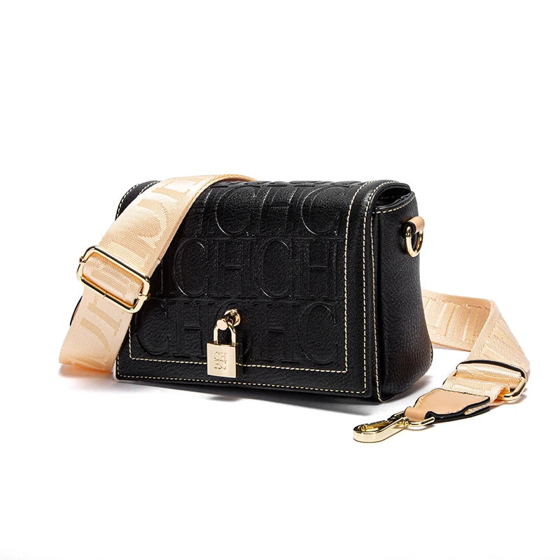 Black handbag with beige strap on a white background
