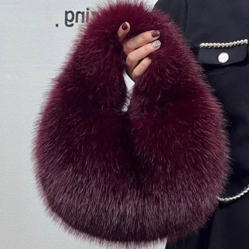 Maroon faux fur scarf held by a person against a plain background