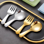 Set of gold and silver cutlery on a black tray with a gold rim.