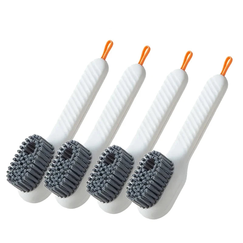 Four white scrub brushes with orange ends on a white background