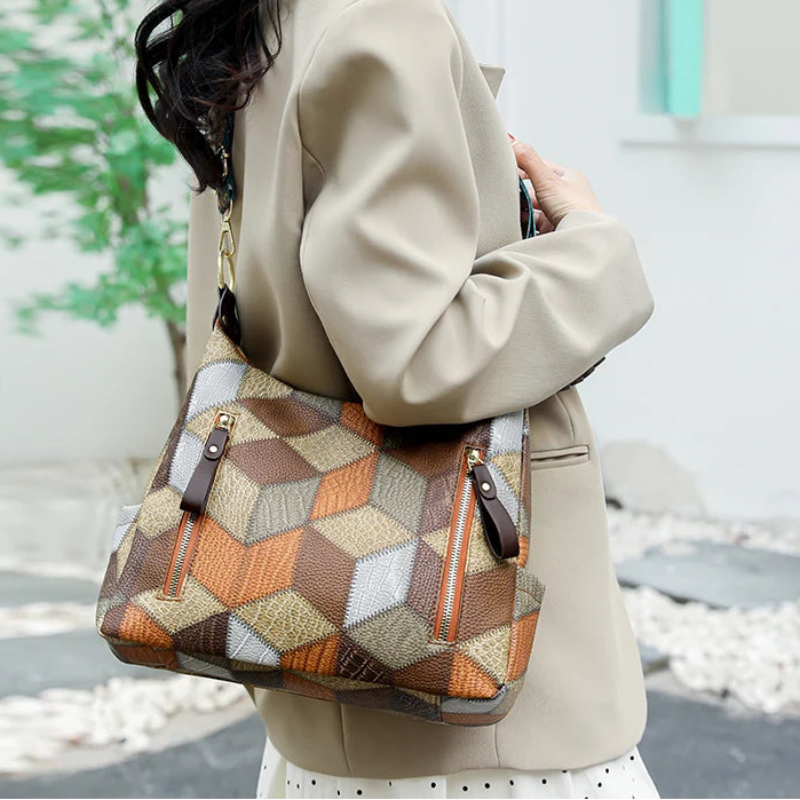 Person holding a patterned handbag with a blurred background