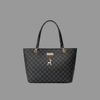 Black patterned handbag with a dog charm on a wooden surface