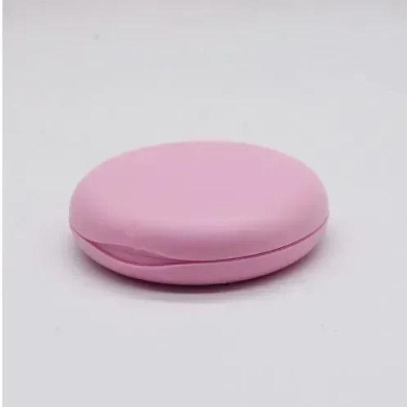 Pink round compact on a light gray background