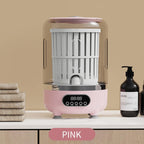 Pink and gray electronic device on a beige surface with towels and bottles in the background