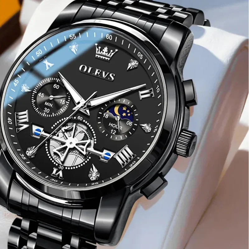 Black OLEVS watch with detailed face and metal strap on a white background