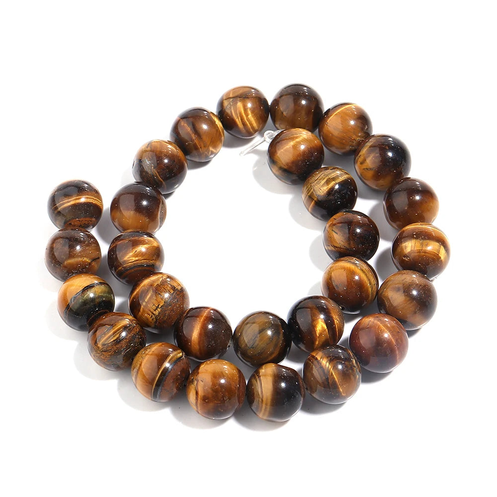 A strand of polished round tiger's eye beads, arranged in a double loop on a clean white background.