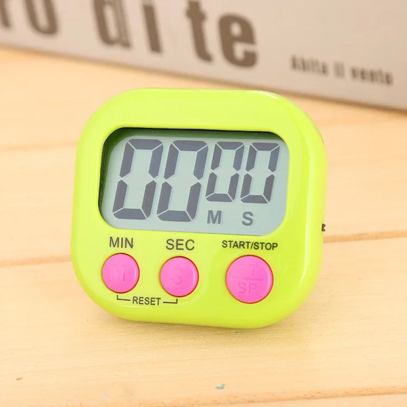 A lime green digital kitchen timer with pink buttons, sitting on a light wooden surface.