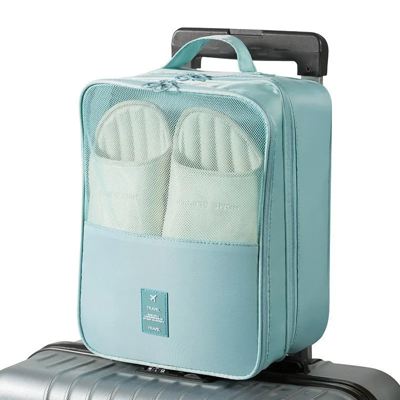 Light blue shoe organizer with white slippers inside, attached to a suitcase on a white background