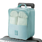 Light blue shoe organizer with white slippers inside, attached to a suitcase on a white background