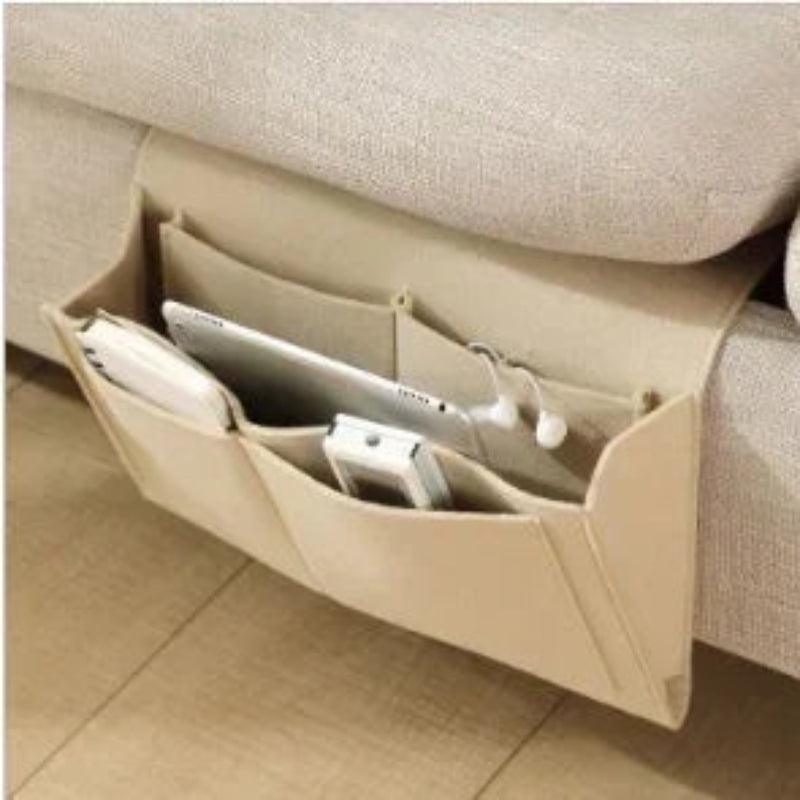 Beige sofa caddy with compartments holding electronic devices on a beige couch.