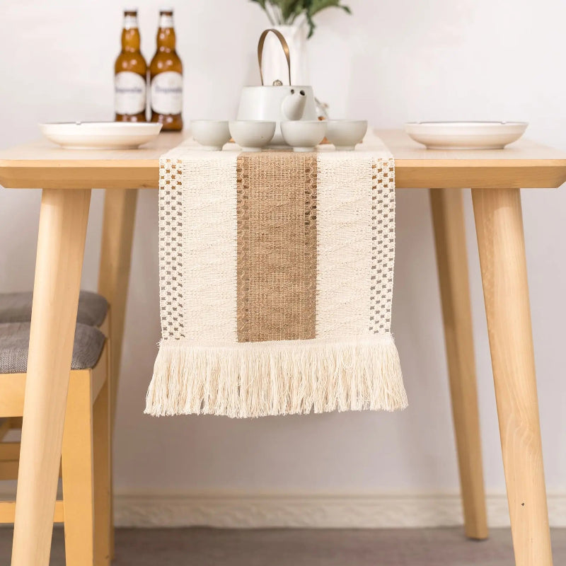 Dining table with a woven runner and ceramic items on a neutral background