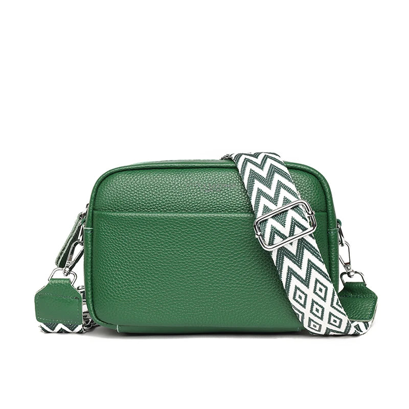 Green leather crossbody bag with a patterned strap on a white background