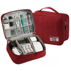 Red travel organizer with compartments filled with electronic devices on a white background