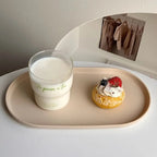 Glass of milk and a dessert with berries on a beige tray.
