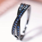 Silver ring with blue gemstones on a blurred background