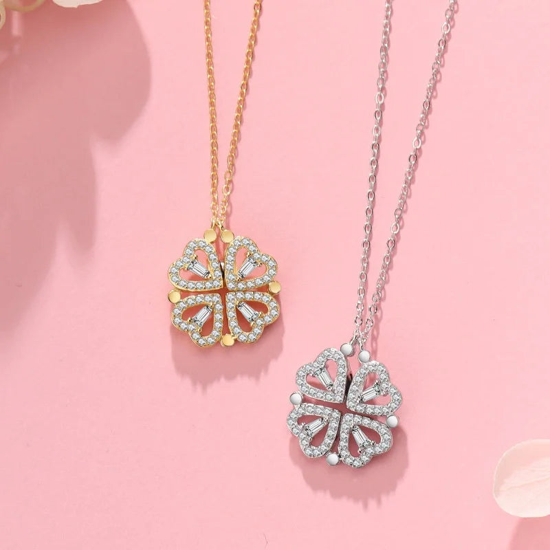 Two butterfly-shaped pendants on gold and silver chains against a pink background
