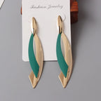 Gold and green earrings on a gray background with 'Fashion Jewelry' label.