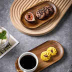 Two wooden trays with a cup of coffee, cookies, and figs on a gray surface.