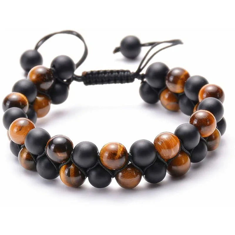 A beaded stretch bracelet featuring alternating matte black beads and polished brown tiger's eye beads, secured with a black adjustable cord on a white background.