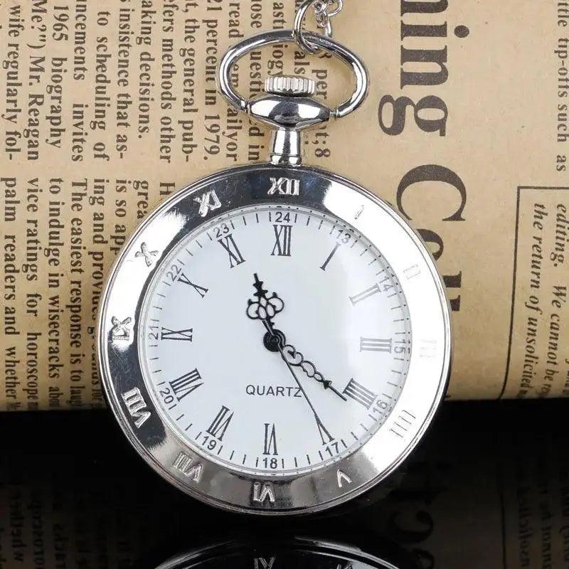 Silver pocket watch with Roman numerals on a textured surface