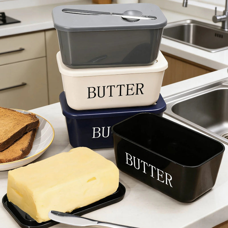 Butter containers with a block of butter on a kitchen counter.