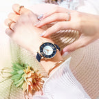 Hand wearing a watch with a blurred background