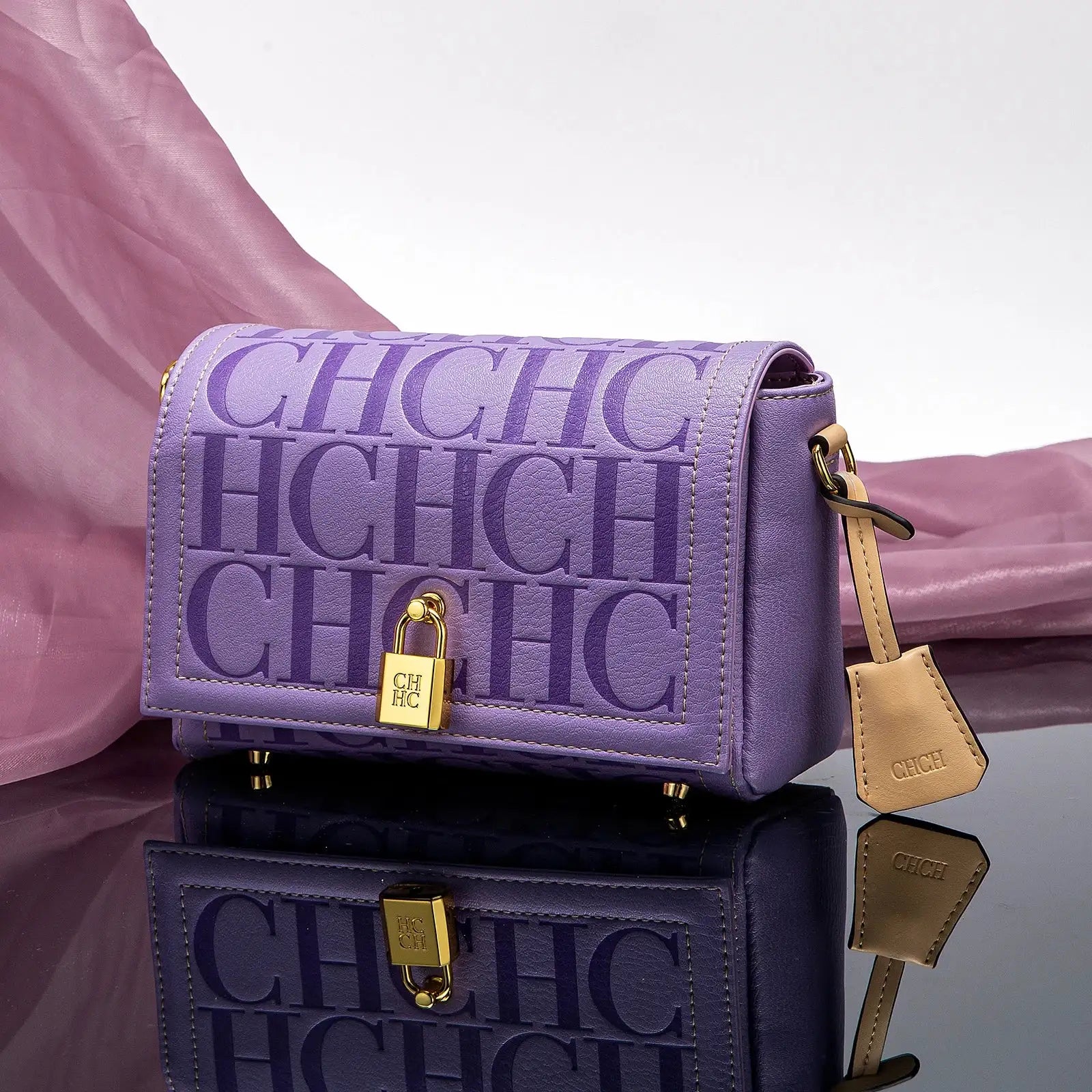 Purple handbag with 'CHIC' text and gold lock on a reflective surface