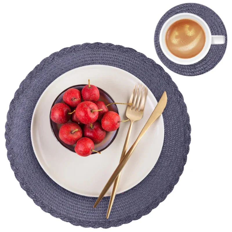 Table setting with blue placemats, red apples, gold fork and knife, and a cup of coffee.