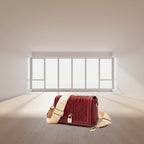 Red handbag with beige strap on a light gray background