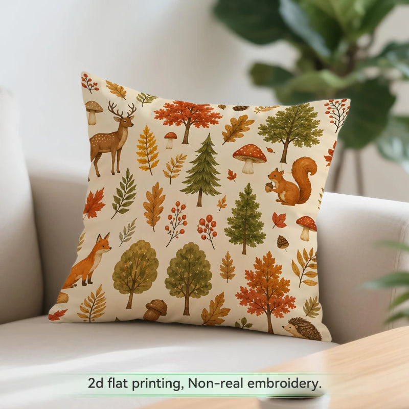 A square throw pillow with a woodland autumn pattern featuring trees, leaves, squirrels, foxes, and mushrooms on a cream background, styled on a light-colored sofa with a green plant in the background.