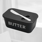 Black butter container with a white label on a light gray background