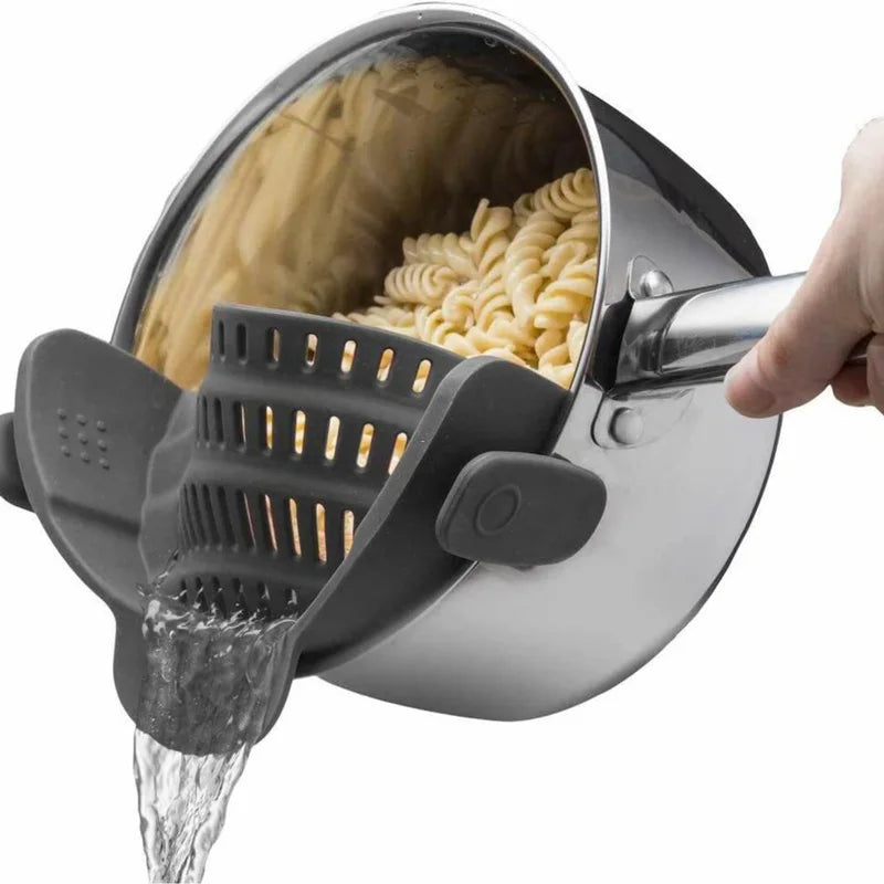 Pasta being drained from a pot with a strainer