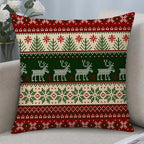 A square throw pillow with a festive Christmas knit pattern in red, green, and cream, resting on a light gray sofa.