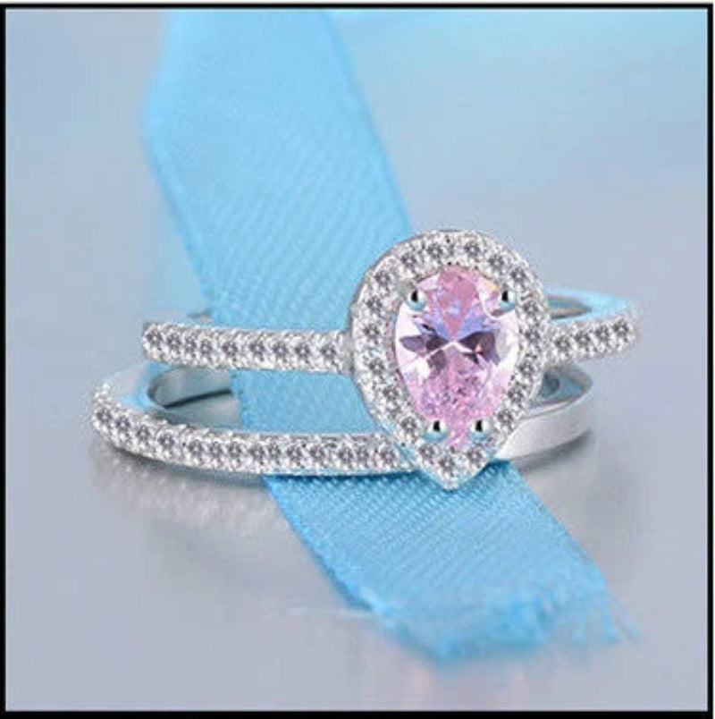 Silver ring with a pink gemstone on a light blue ribbon