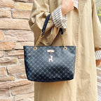 Person holding a blue patterned handbag with a gold chain strap against a stone wall.