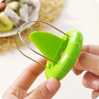 Green apple peeler held by a hand with a blurred background