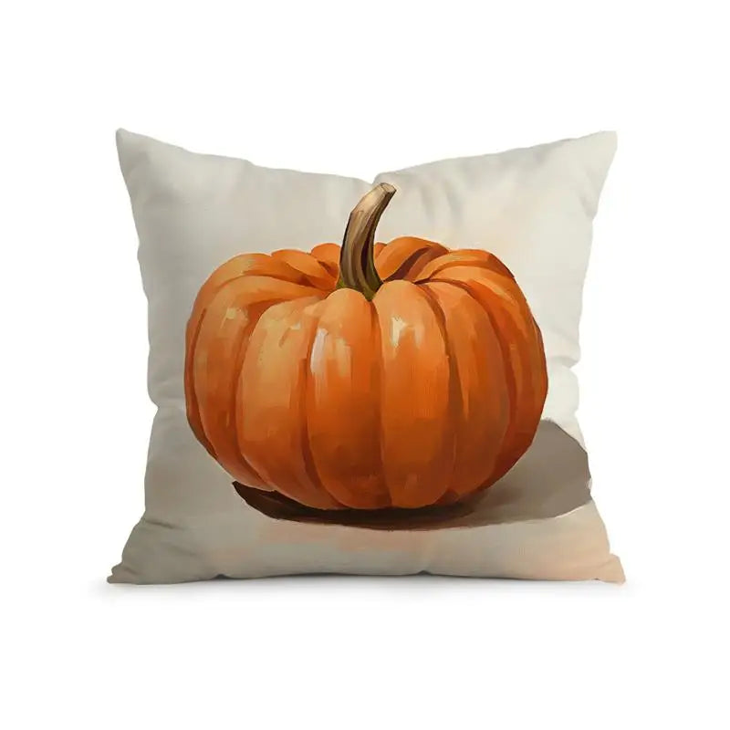 A square throw pillow featuring a printed illustration of a bright orange pumpkin with a brown stem on a light beige fabric background, shown against a plain white studio backdrop.