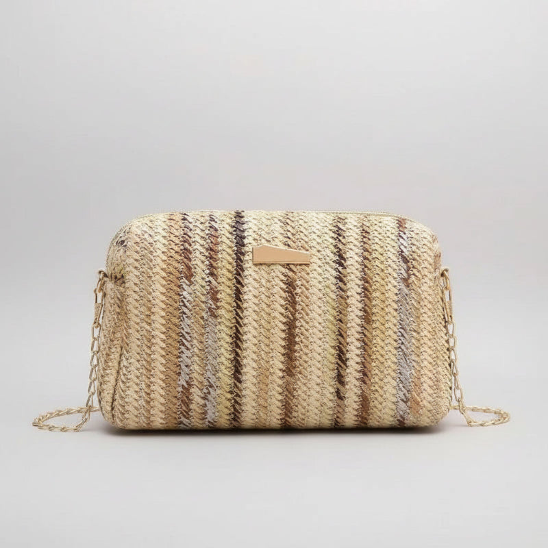 Woven handbag with a chain strap on a beige background with yellow tulips.
