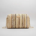 Woven handbag with a chain strap on a beige background with yellow tulips.