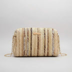 Woven handbag with a chain strap on a beige background with yellow tulips.