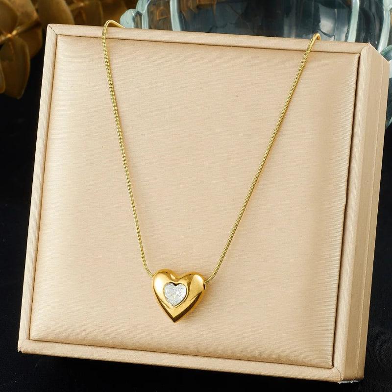 Gold heart-shaped necklace on a beige jewelry box