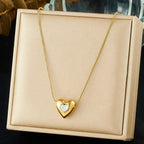 Gold heart-shaped necklace on a beige jewelry box