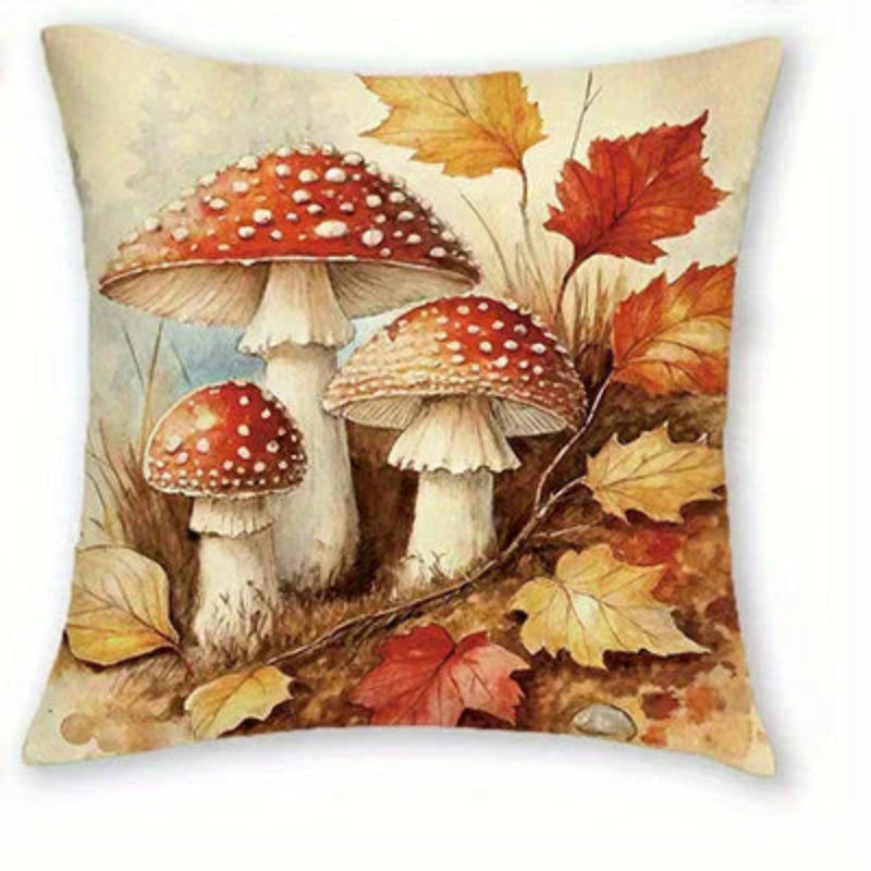 Square decorative throw pillow featuring a vintage-style illustration of three red-and-white spotted mushrooms surrounded by autumn leaves in warm beige, orange, and brown tones.