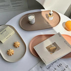 Table setting with trays, a candle, and a magazine on a white surface.