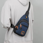 Person wearing a blue and black crossbody bag with orange accents on a gray background