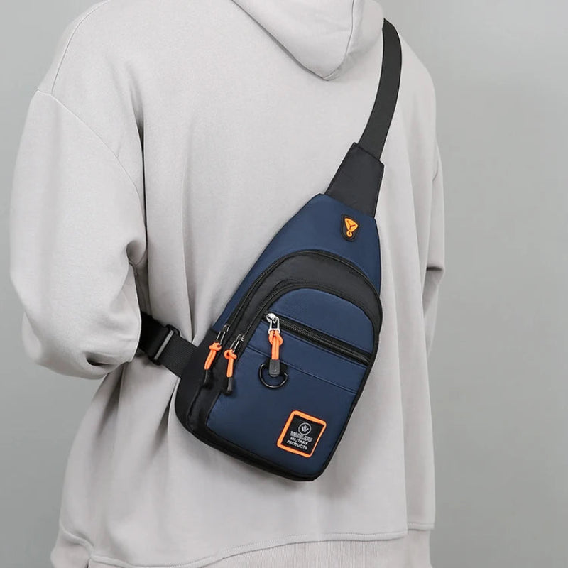 Person wearing a blue and black crossbody bag with orange accents on a gray background