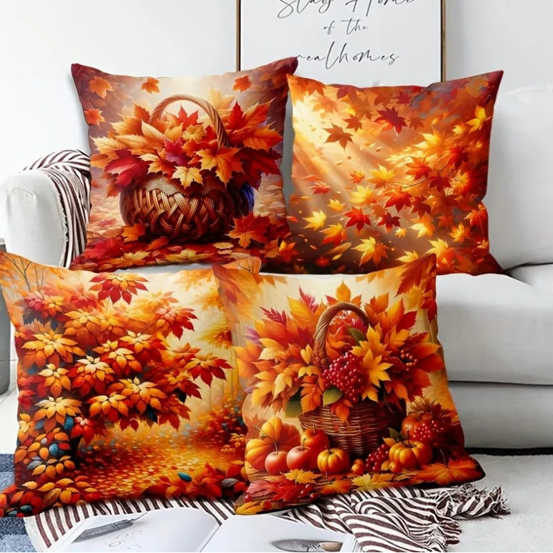 Three decorative pillows with autumn-themed designs on a couch.