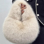 White fluffy bag held by a person wearing a dark coat with white buttons.